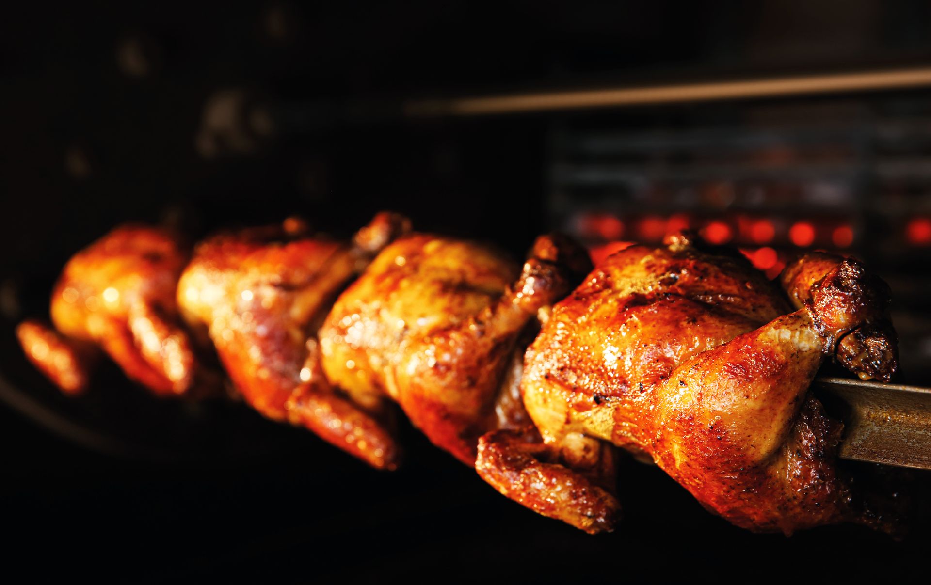 Pollos asados girando al fuego en el asador de Asador Campaña, Priego de Córdoba